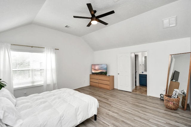 bedroom featuring lofted ceiling, ceiling fan, light wood-type flooring, and ensuite bathroom