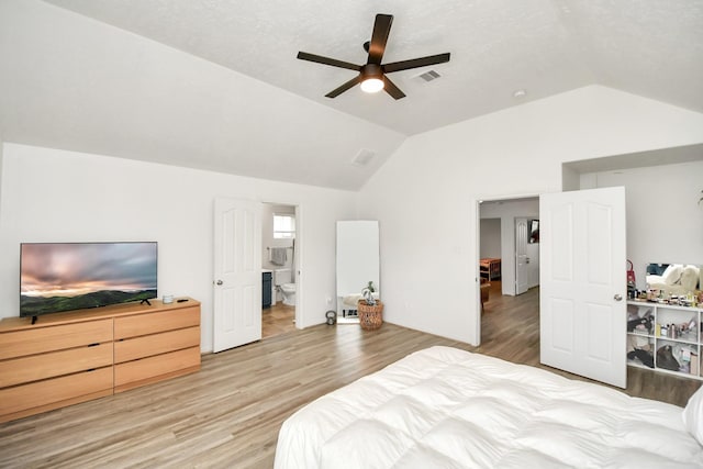 bedroom featuring ceiling fan, light hardwood / wood-style floors, connected bathroom, and vaulted ceiling