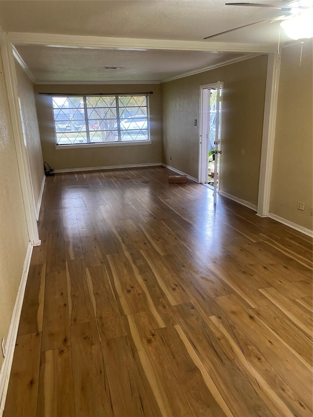 unfurnished room featuring crown molding, hardwood / wood-style floors, ceiling fan, and a textured ceiling