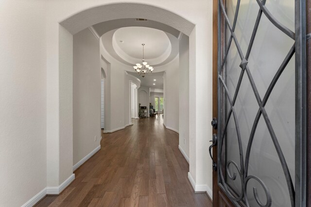 corridor featuring dark wood-type flooring and a chandelier