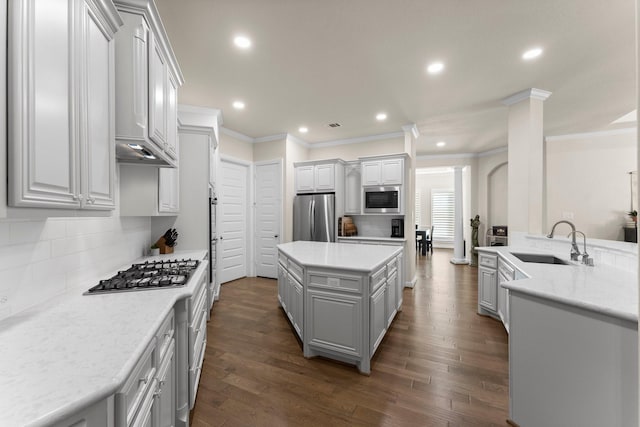 kitchen featuring stainless steel appliances, a kitchen island, dark hardwood / wood-style floors, and sink