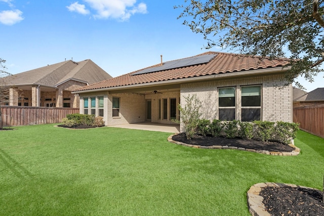 back of house featuring solar panels, a patio, ceiling fan, and a lawn