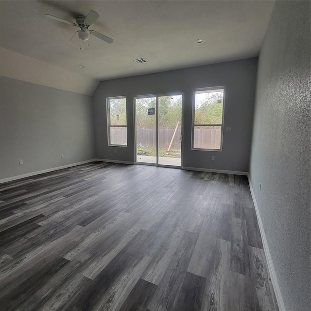 empty room featuring ceiling fan, dark hardwood / wood-style flooring, and vaulted ceiling