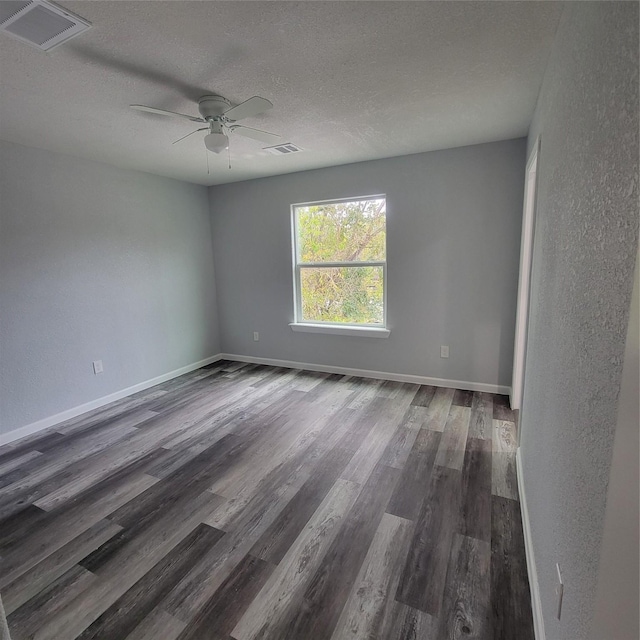 empty room featuring ceiling fan, dark hardwood / wood-style flooring, and a textured ceiling