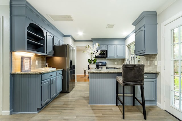 kitchen featuring stainless steel appliances, light hardwood / wood-style flooring, backsplash, kitchen peninsula, and crown molding