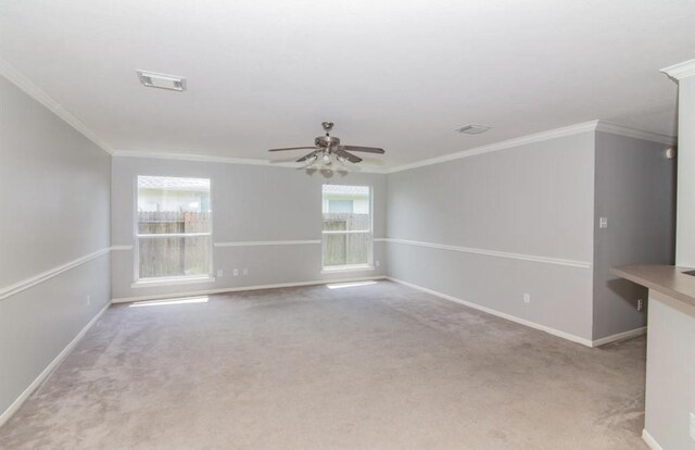 spare room featuring crown molding, ceiling fan, and light colored carpet