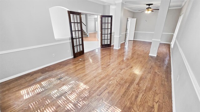 empty room featuring crown molding, french doors, ceiling fan, and hardwood / wood-style flooring