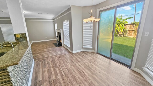 interior space featuring a chandelier, sink, light hardwood / wood-style floors, and ornamental molding