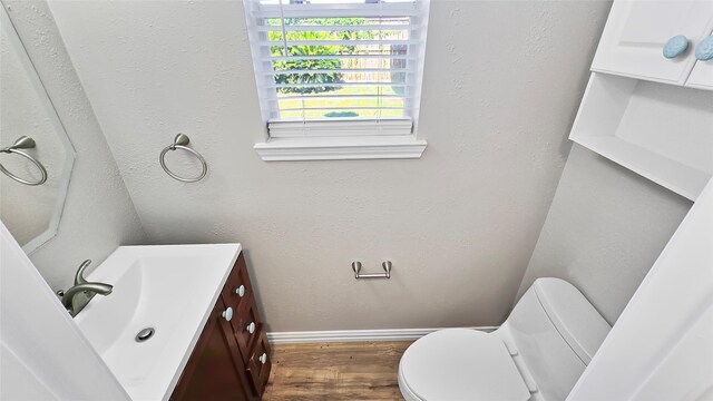 bathroom with hardwood / wood-style floors, vanity, and toilet