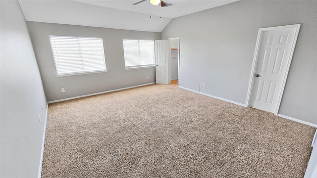 spare room featuring light carpet and vaulted ceiling