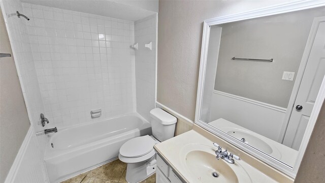 full bathroom with tile patterned floors, vanity, toilet, and tiled shower / bath combo