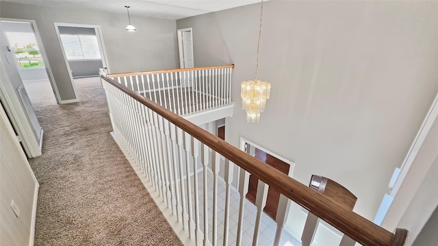 hallway with carpet floors, a high ceiling, and a notable chandelier