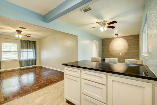 kitchen featuring dark stone counters, white cabinets, and light hardwood / wood-style floors