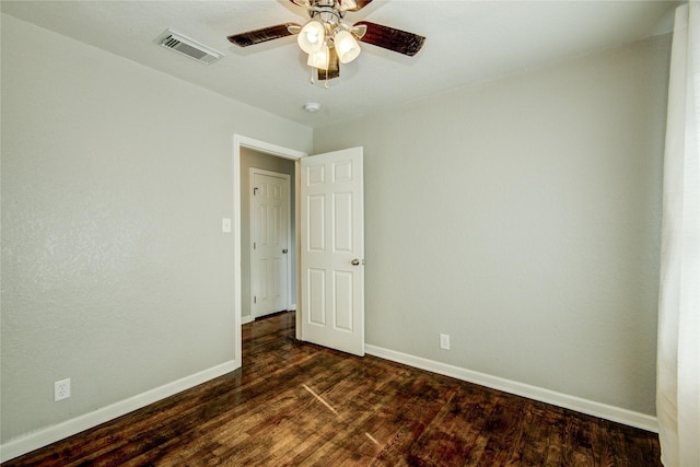 spare room featuring ceiling fan and dark wood-type flooring