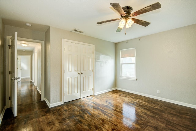 unfurnished bedroom featuring ceiling fan, dark hardwood / wood-style floors, and a closet