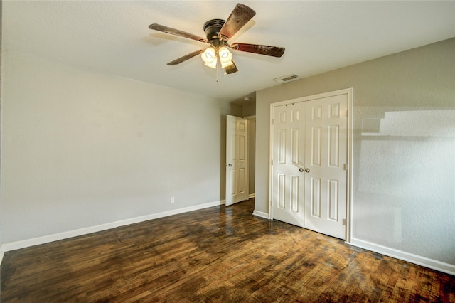 unfurnished bedroom featuring ceiling fan, dark hardwood / wood-style floors, and a closet