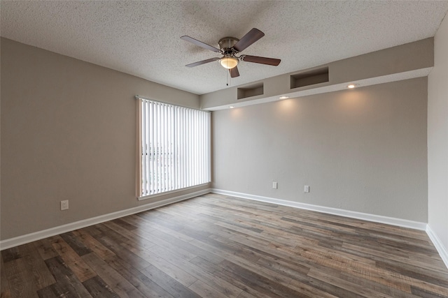 empty room with ceiling fan, dark hardwood / wood-style floors, and a textured ceiling