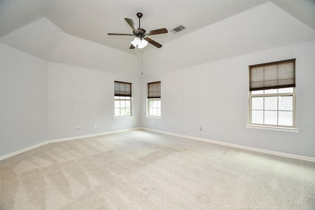 empty room with carpet, lofted ceiling, ceiling fan, and a healthy amount of sunlight