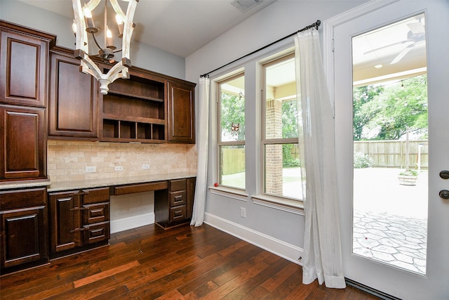 interior space with ceiling fan with notable chandelier, dark hardwood / wood-style flooring, and built in desk