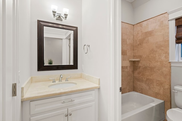 full bathroom featuring tiled shower / bath, vanity, and toilet