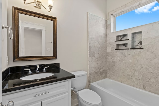 full bathroom featuring tiled shower / bath, vanity, and toilet