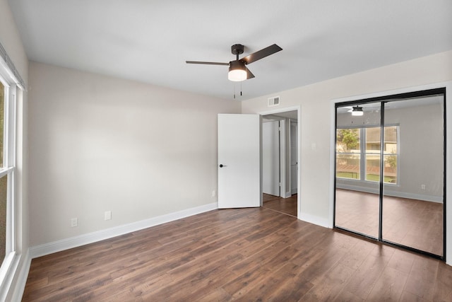 unfurnished bedroom featuring a closet, dark hardwood / wood-style floors, and ceiling fan