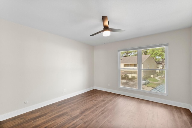 spare room with ceiling fan and dark wood-type flooring