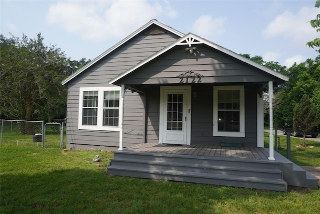 rear view of property with a lawn and a porch