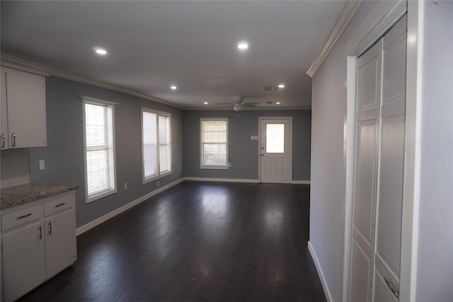 interior space with dark hardwood / wood-style floors, plenty of natural light, crown molding, and ceiling fan