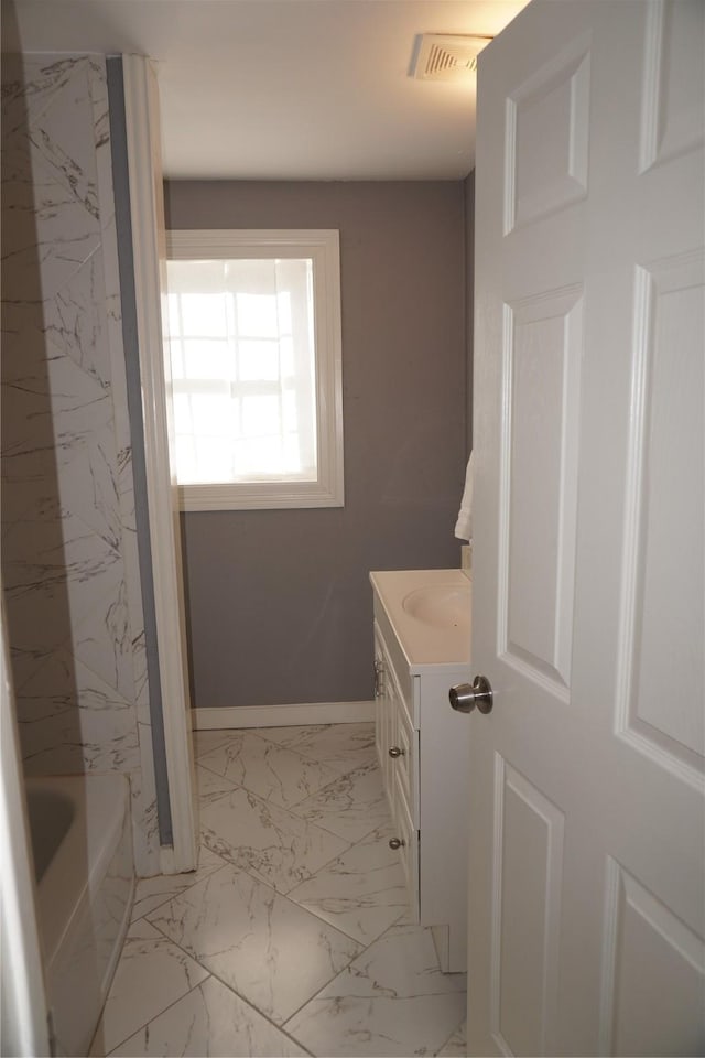 bathroom featuring vanity and a tub