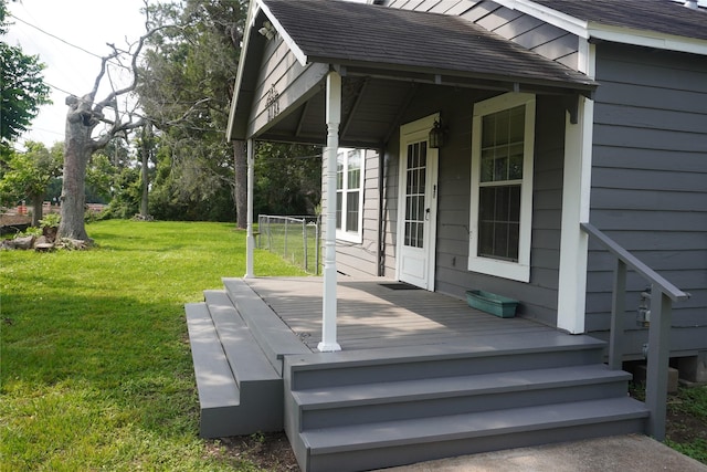 wooden terrace featuring a porch and a lawn