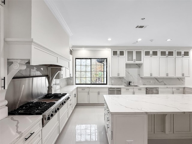 kitchen featuring decorative backsplash, white cabinetry, and light stone countertops