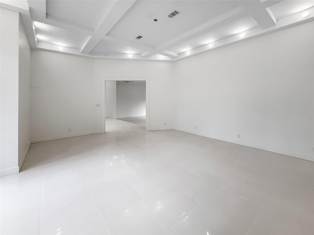 tiled spare room featuring beam ceiling and coffered ceiling