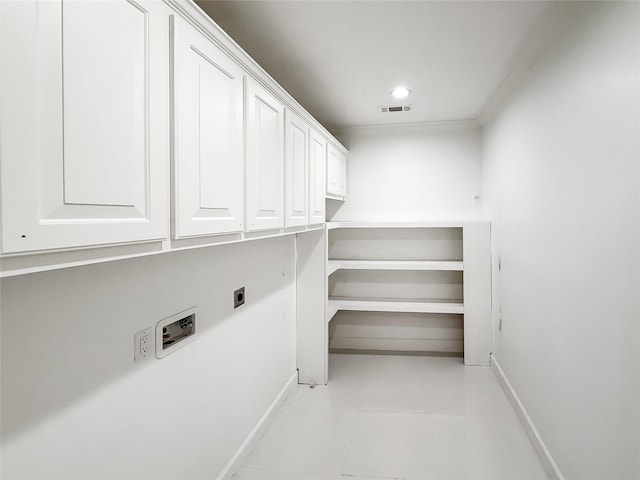 clothes washing area featuring electric dryer hookup and cabinets