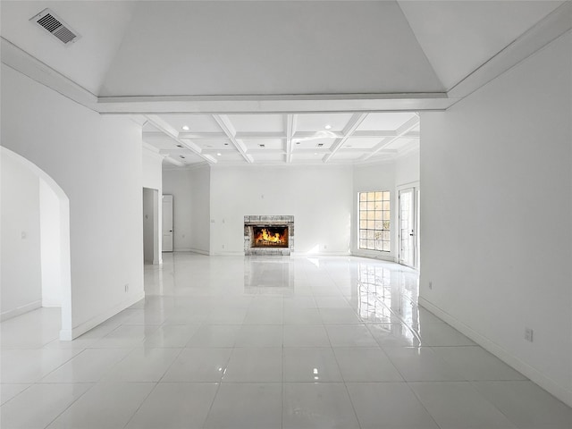 unfurnished living room with beamed ceiling, light tile patterned flooring, a high ceiling, and coffered ceiling