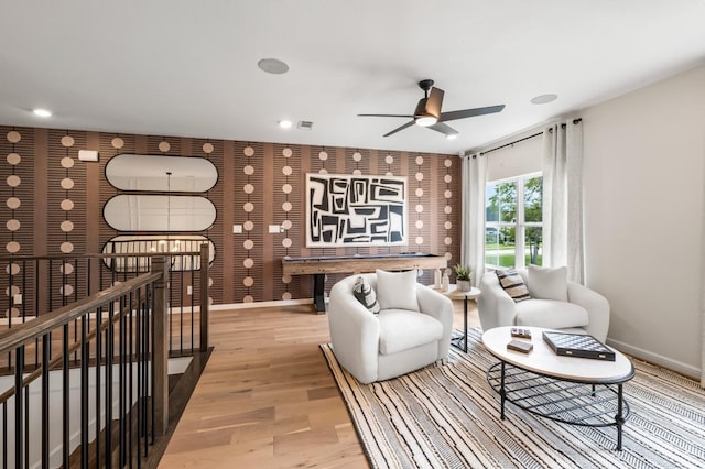 living area with ceiling fan and light hardwood / wood-style flooring