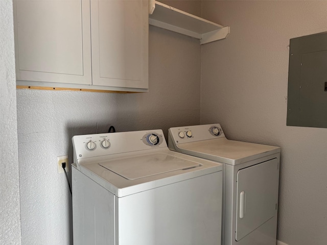 clothes washing area featuring cabinets, washing machine and dryer, and electric panel