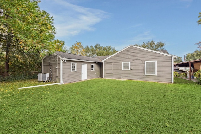 back of property featuring central AC and a lawn