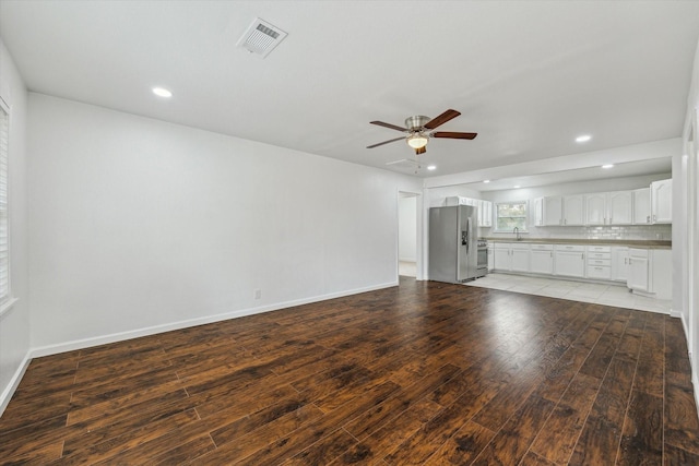 unfurnished living room featuring ceiling fan and light hardwood / wood-style flooring