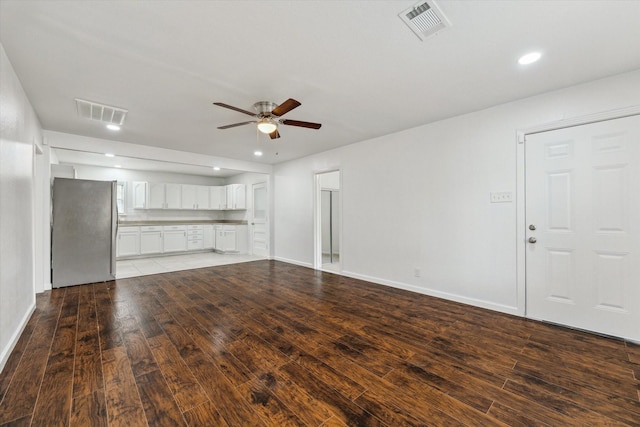 unfurnished living room featuring ceiling fan and dark hardwood / wood-style flooring