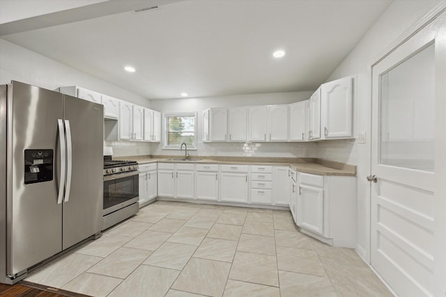 kitchen with white cabinets, stainless steel appliances, tasteful backsplash, and sink