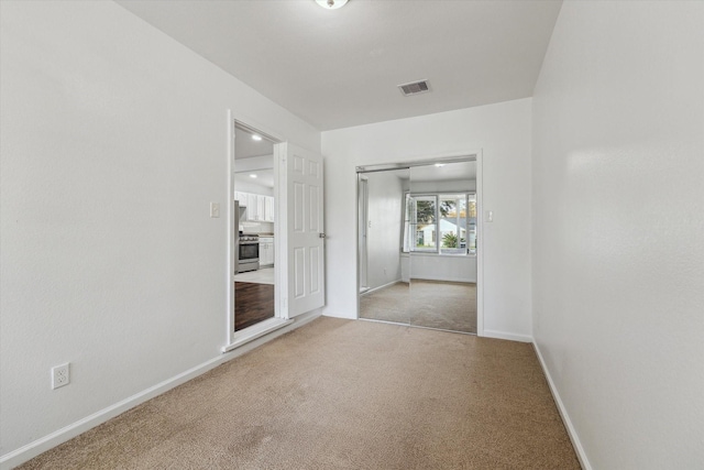 spare room featuring light carpet