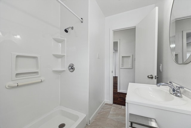 bathroom featuring tile patterned flooring, vanity, and walk in shower