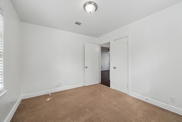 unfurnished bedroom featuring carpet flooring and multiple windows