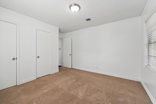 unfurnished bedroom with light colored carpet and crown molding