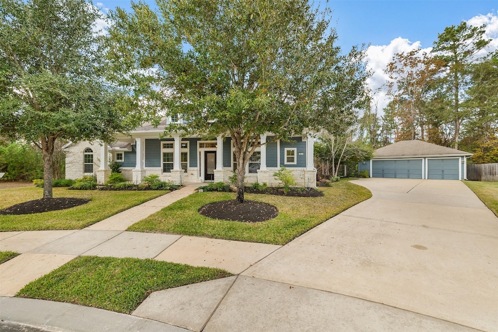 view of front of home with an outbuilding, a front lawn, covered porch, and a garage