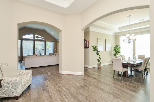 dining room featuring hardwood / wood-style floors, a chandelier, and lofted ceiling