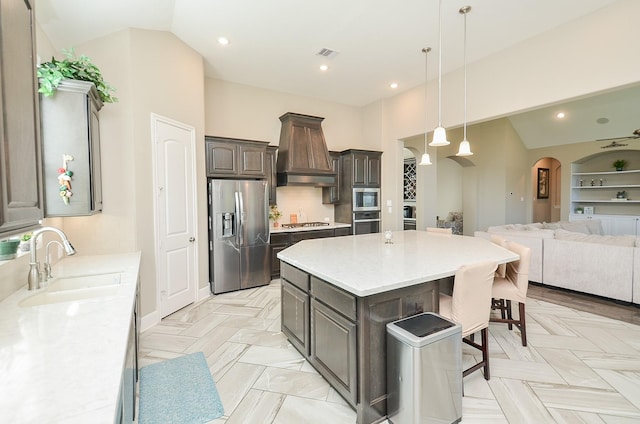 kitchen with sink, tasteful backsplash, high vaulted ceiling, a kitchen island, and appliances with stainless steel finishes