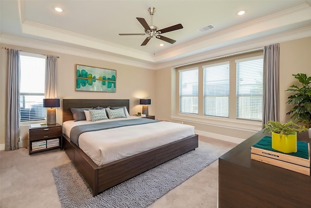 carpeted bedroom with a raised ceiling, ceiling fan, and ornamental molding