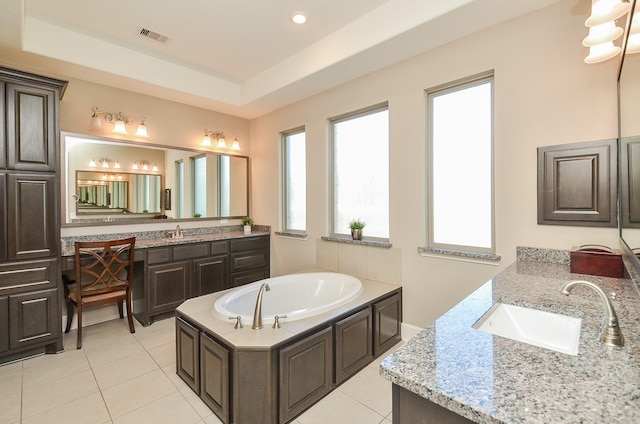 bathroom with tile patterned flooring, a tub to relax in, vanity, and a tray ceiling